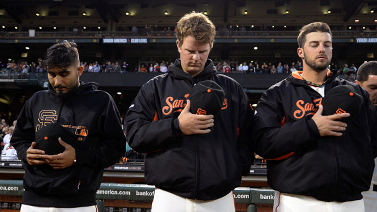 San Francisco Giants' pitchers (L-R) Sergio Romo, Matt Cain, and George Kontos bow their heads during a moment of silence for Dodger fan Johnathan Denver prior to playing the Los Angeles Dodgers at AT&T Park on September 26, 2013 in San Francisco, California. Denver was fatally stabbed during a fight away from the ball park after Wednesday night game between the Dodgers and Giants. (Thearon W. Henderson/Getty Images)