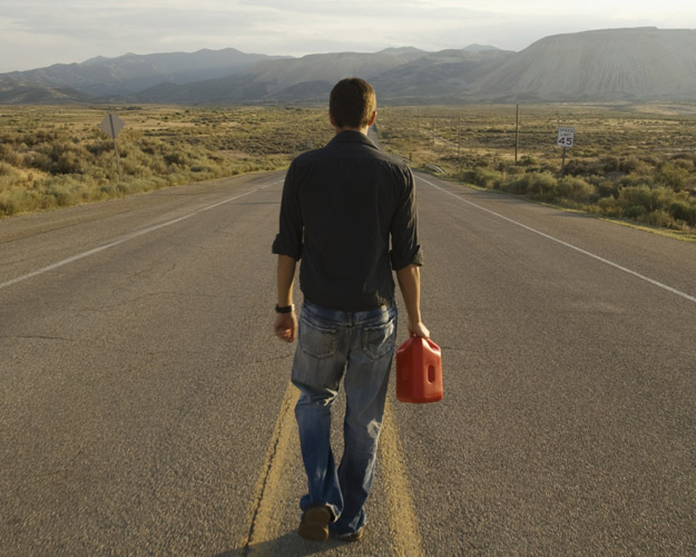 Man walking in road with gas can