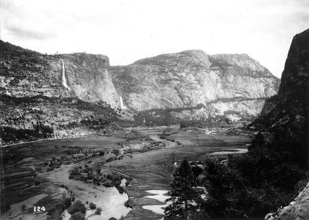 View across Hetch Hetchy Valley, early 1900s, from the southwestern end, showing the Tuolumne River flowing through the lower portion of the valley prior to damming. (Isaiah West Taber [Public domain], via Wikimedia Commons)