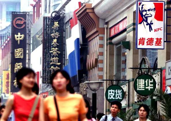 Chinese shoppers walk through Beijing's main downtown shopping promenade past a KFC franchise. (STEPHEN SHAVER/AFP/Getty Images)