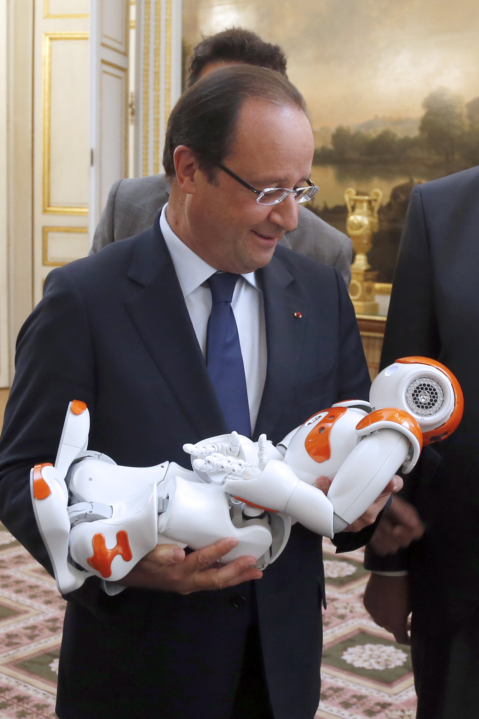 France's President Francois Hollande holds an humanoid robot 