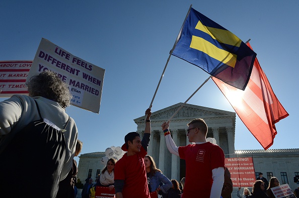 Protesters hold pro-gay rights flags outside the US Supreme Court. (Photo by Olivier Douliery/Getty Images)