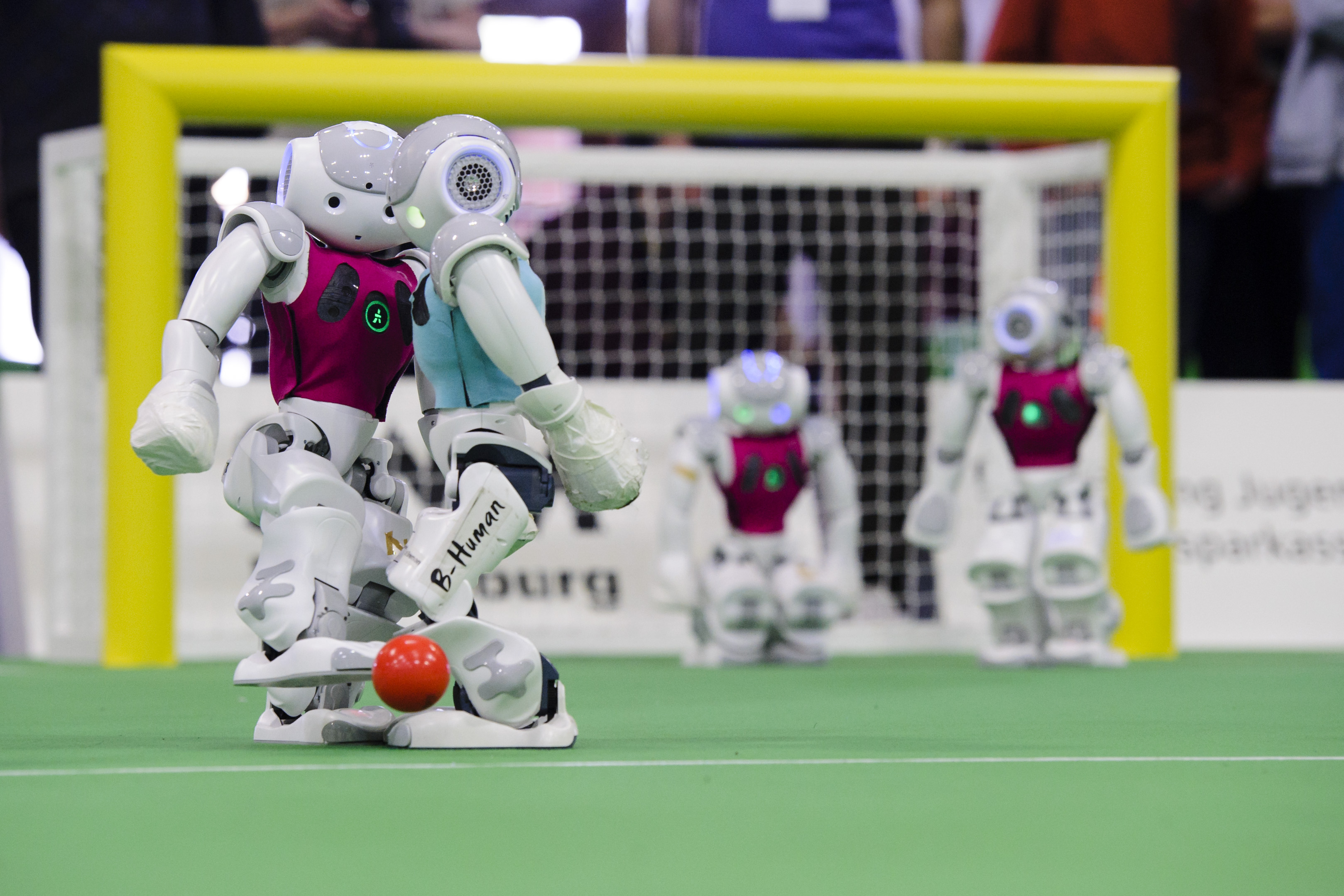 Two teams of NAO robots compete in the 2014 RoboCup German Open tournament. (Photo by Jens Schlueter/Getty Images)