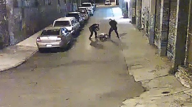 A frame from a surveillance video showing sheriff deputies beating a man with batons in S.F. Mission District. (SF Public Defenders Office)
