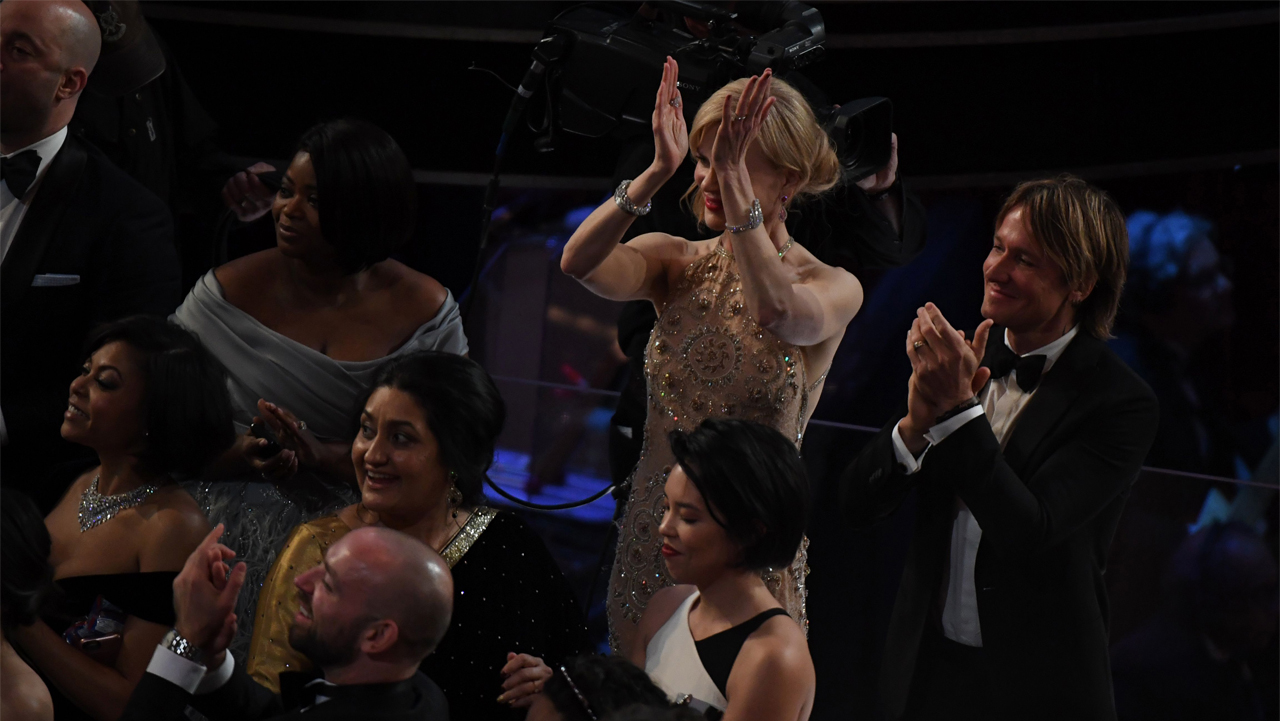 Nominee for Best Supporting Actress in "Lion" Nicole Kidman (C), her husband Australian singer Keith Urban (R) and nominee for Best Supporting Actress in "Hidden Figures" Octavia Spencer applaud as tourists are brought into the Oscars as a surprise at the 89th Oscars on February 26, 2017 in Hollywood, California. / AFP / Mark RALSTON        (Photo credit should read MARK RALSTON/AFP/Getty Images)