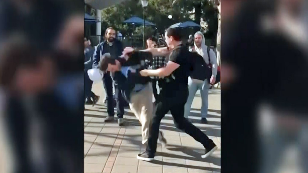 A man punches another man at Sproul Plaza on the UC Berkeley campus.