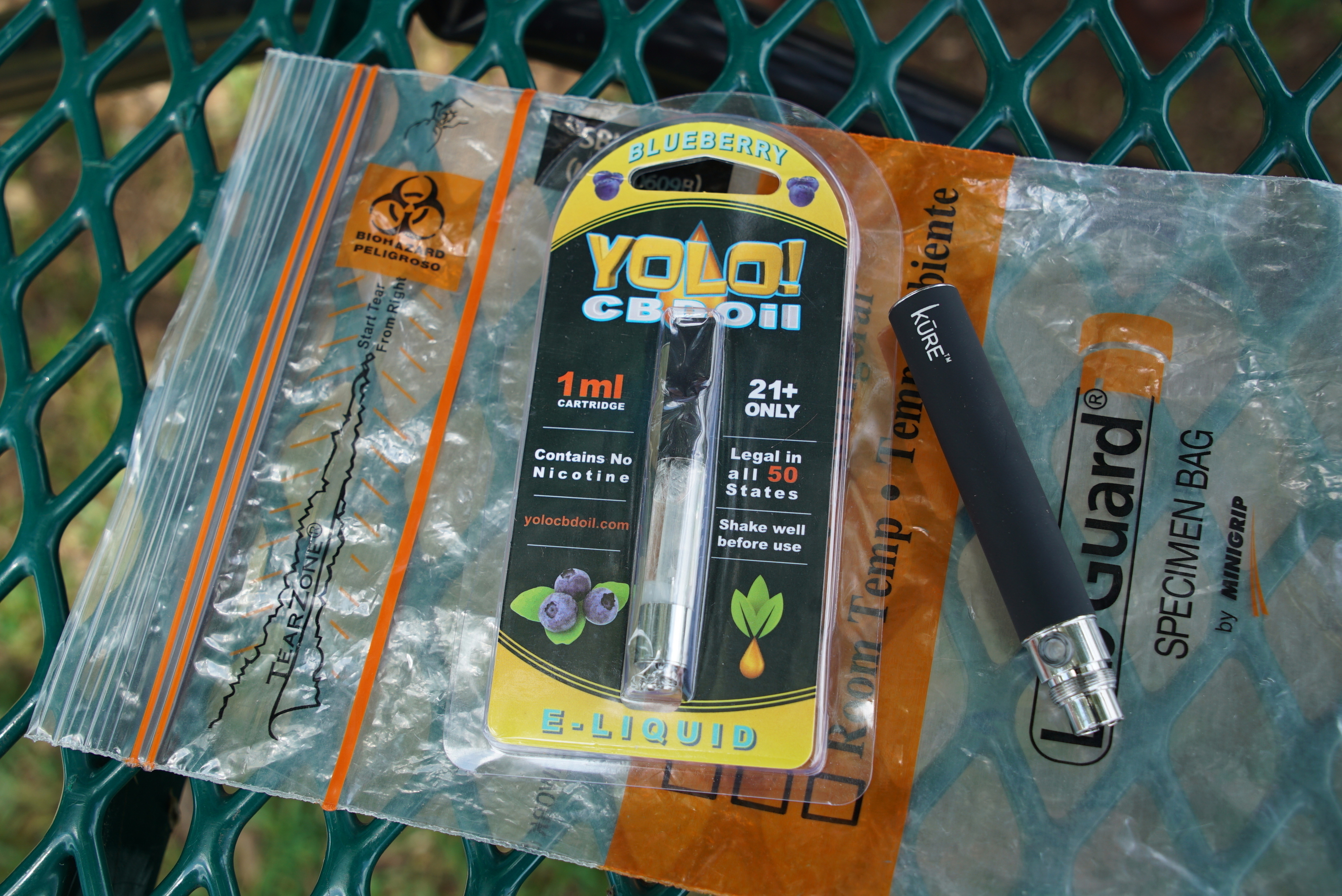A Yolo! brand CBD oil vape cartridge sits alongside a vape pen on a biohazard bag on a table at a park in Ninety Six, S.C. More than 50 people around Salt Lake City had been poisoned by the time the outbreak ended early last year, most by a vape called Yolo!, the acronym for "you only live once." (AP Photo/Allen G. Breed, File)