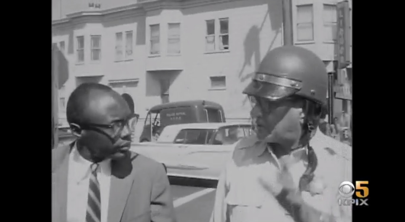 Willie Brown, long before his time as mayor of San Francisco, being interrupted by a San Francisco Police officer during unrest following the shooting death of Matthew "Peanut" Johnson in 1966. (CBS)