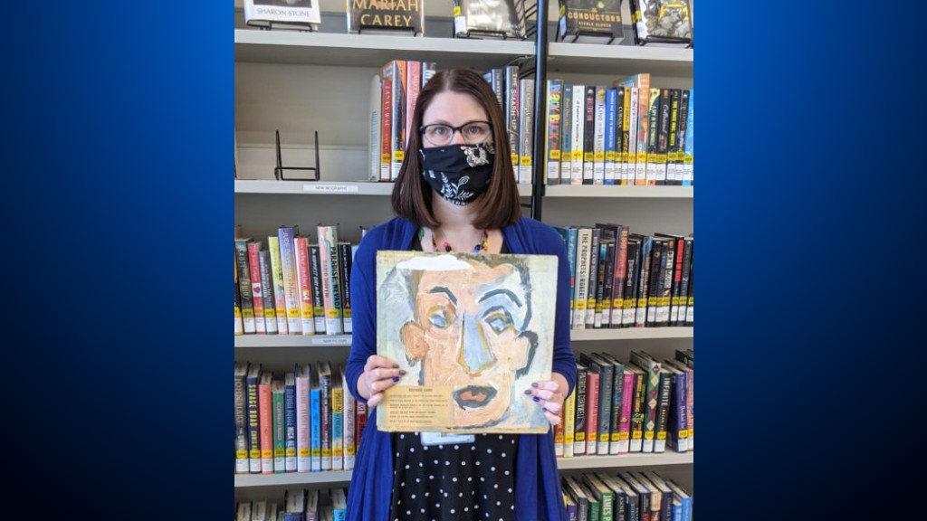 Sara Philips, branch manager of the University Heights branch library in Ohio, holds up the Bob Dylan album "Self Portrait" which was checked out by Howard Simon in 1973. Simon, who now lives in San Francisco, returned the album in May 2021. (Heights Libraries)
