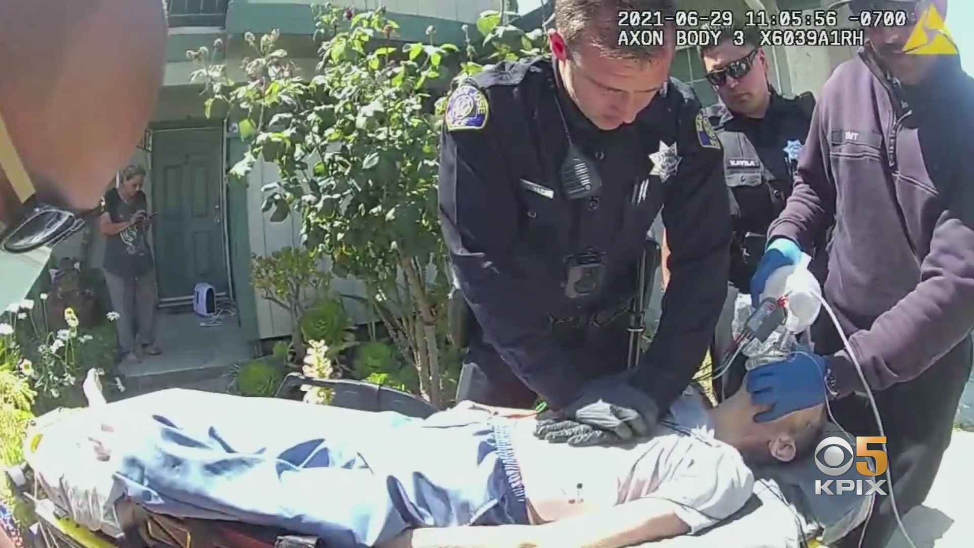 Body cam footage of Officer Christopher Reed performing chest compressions on a woman who suffered a heart attack following a house fire on June 29, 2021. (CBS)