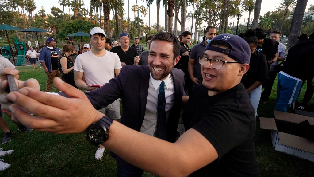 In this Friday, Aug, 20, 2021, Kevin Paffrath, center, a real estate agent and YouTube content creator, center, takes a selfie with follower, at a campaign rally at Echo Park Lake in Los Angeles. Paffrath, 29, is one of the Democrats running in the recall against California Gov. Gavin Newsom. (AP Photo/Damian Dovarganes)